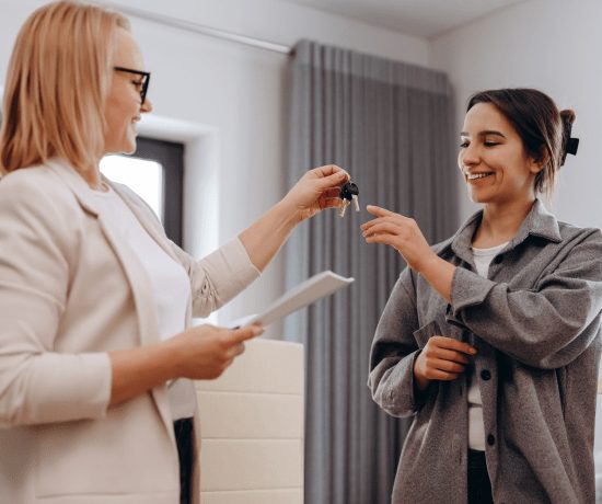 Real estate agent handing house keys to a smiling new tenant